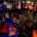 Fans gather outside University of Cincinnati Medical Center, Monday, Jan. 2, 2023, in Cincinnati, where Buffalo Bills’ Damar Hamlin was taken after collapsing on the field during an NFL football game against the Cincinnati Bengals. (AP Photo/Jeff Dean)